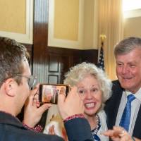 Haas and Marcia take a picture with guest